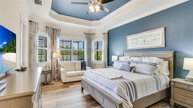 20359 Cristoforo Pl, Venice, FL 34293 - bedroom featuring wood finished floors, crown molding, a tray ceiling, and a ceiling fan