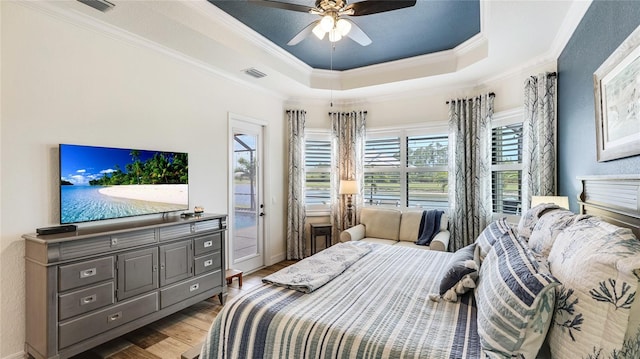 20359 Cristoforo Pl, Venice, FL 34293 - bedroom with wood finished floors, a tray ceiling, crown molding, access to outside, and ceiling fan