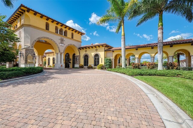 20359 Cristoforo Pl, Venice, FL 34293 - mediterranean / spanish-style home with curved driveway, stucco siding, and a tile roof