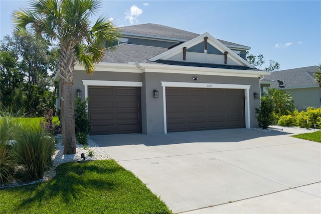 view of front facade featuring concrete driveway, stucco siding, and a garage