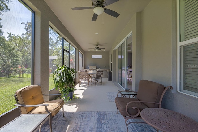 sunroom featuring outdoor dining space, an outdoor kitchen, and ceiling fan