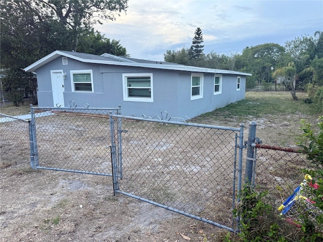exterior space featuring stucco siding, a gate, and fence