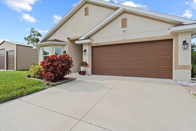 4466 Manila Ave, North Port, FL 34288 - view of front of property with stucco siding, an attached garage, driveway, and an outbuilding