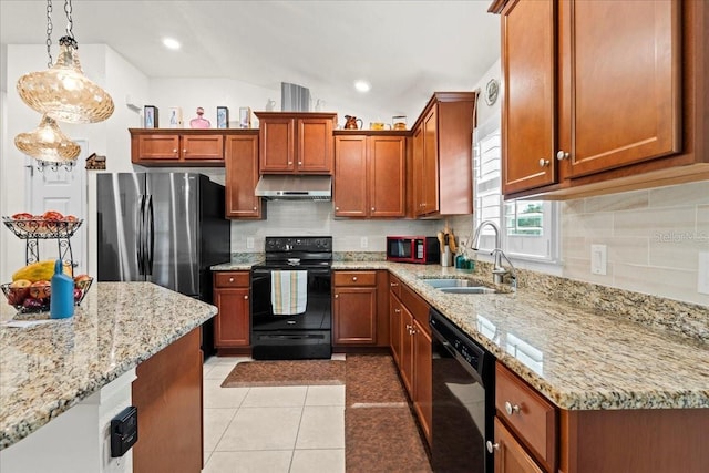4466 Manila Ave, North Port, FL 34288 - kitchen with black appliances, a sink, under cabinet range hood, decorative backsplash, and light stone countertops