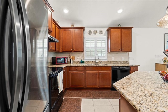 4466 Manila Ave, North Port, FL 34288 - kitchen featuring black appliances, a sink, light stone countertops, under cabinet range hood, and brown cabinetry