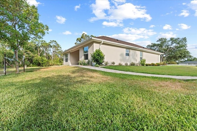 4466 Manila Ave, North Port, FL 34288 - view of side of home featuring stucco siding and a yard