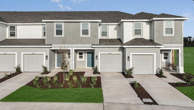 view of property with concrete driveway, a front yard, stucco siding, and a garage