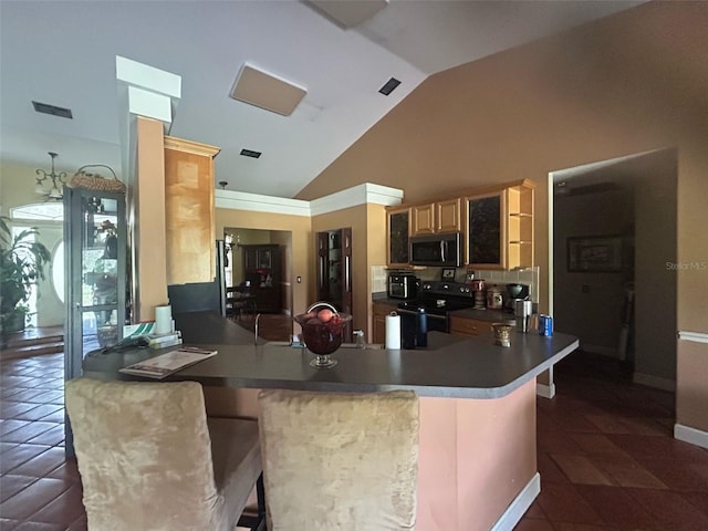 kitchen featuring stainless steel microwave, a peninsula, a breakfast bar area, black / electric stove, and light brown cabinets