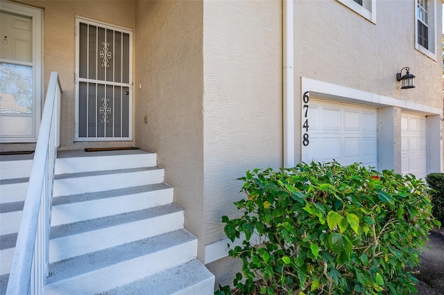 6748 Fairview Ter Unit 4-202, Bradenton, FL 34203 - view of exterior entry featuring stucco siding and an attached garage