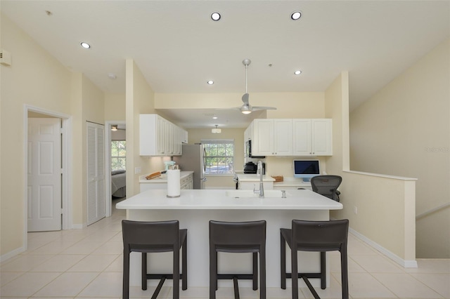 6748 Fairview Ter Unit 4-202, Bradenton, FL 34203 - kitchen with a breakfast bar area, light countertops, light tile patterned floors, white cabinets, and recessed lighting