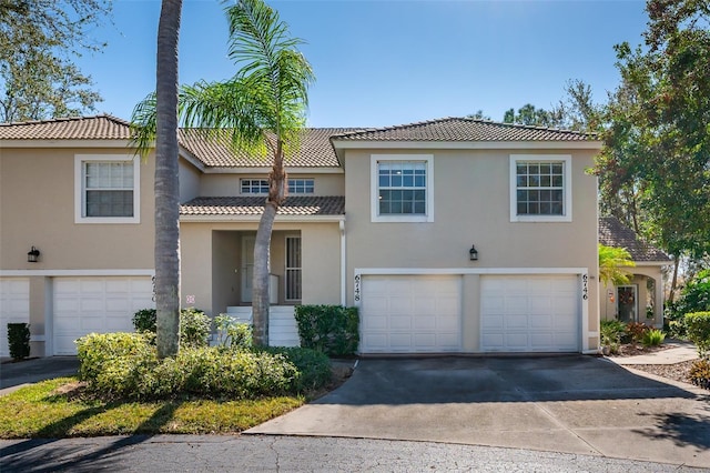 6748 Fairview Ter Unit 4-202, Bradenton, FL 34203 - view of front of house featuring a garage, driveway, stucco siding, and a tile roof