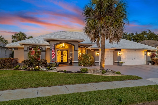 490 Pine Lily Way, Venice, FL 34293 - mediterranean / spanish home featuring a garage, a front lawn, stucco siding, and concrete driveway