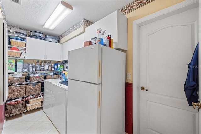 490 Pine Lily Way, Venice, FL 34293 - clothes washing area featuring washer and dryer, a textured ceiling, light tile patterned floors, and cabinet space