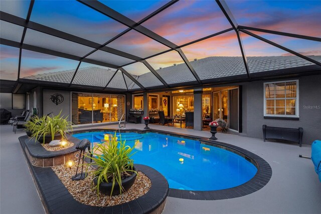 490 Pine Lily Way, Venice, FL 34293 - pool at dusk with a patio area, an outdoor pool, a fire pit, and glass enclosure