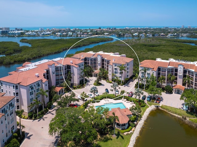 bird's eye view of apartment complex, a large body of water, and a pool