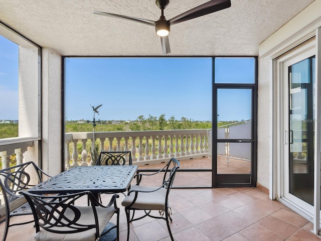 sunroom / solarium featuring a ceiling fan and plenty of natural light