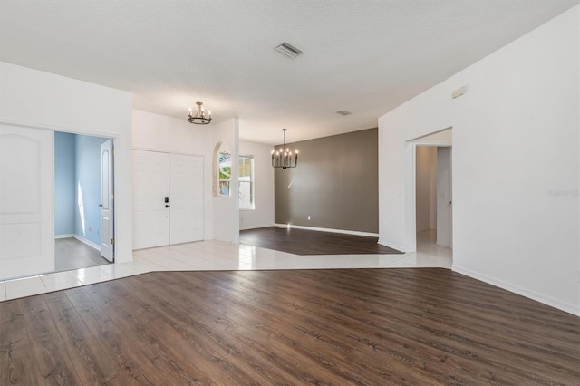 4063 Westbourne Cir, Sarasota, FL 34238 - unfurnished room with a chandelier, wood finished floors, and baseboards