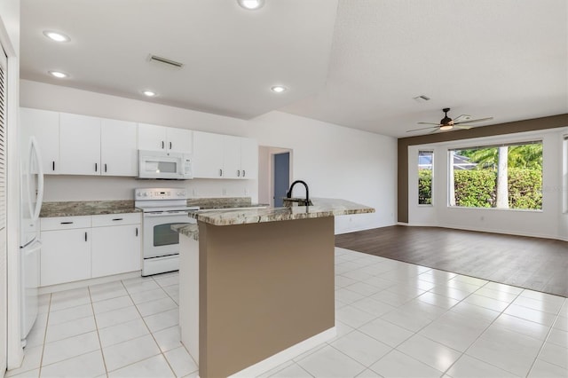 4063 Westbourne Cir, Sarasota, FL 34238 - kitchen featuring white appliances, open floor plan, a center island with sink, a ceiling fan, and light tile patterned floors
