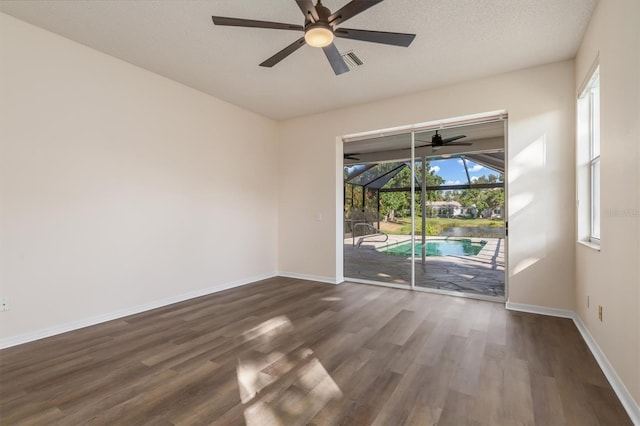 4063 Westbourne Cir, Sarasota, FL 34238 - empty room with a sunroom, a ceiling fan, dark wood-style flooring, and baseboards