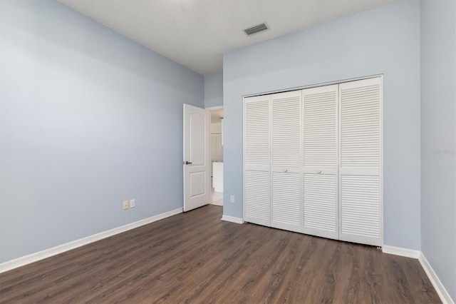 4063 Westbourne Cir, Sarasota, FL 34238 - unfurnished bedroom featuring dark wood-style floors, a closet, and baseboards