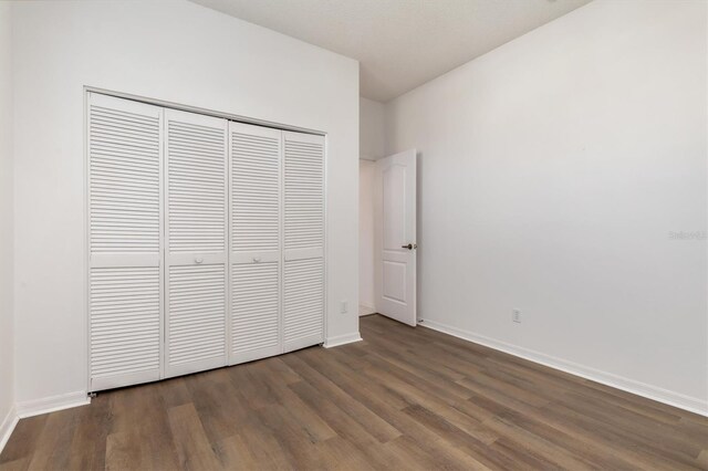 4063 Westbourne Cir, Sarasota, FL 34238 - unfurnished bedroom featuring wood finished floors, a closet, and baseboards