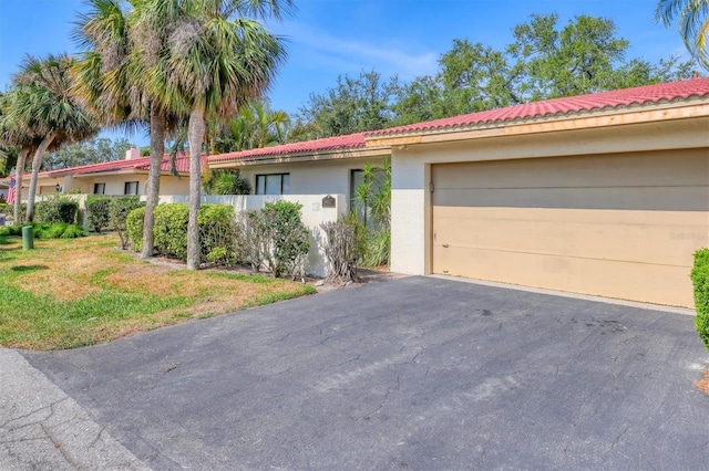 view of front of house featuring stucco siding, asphalt driveway, and a front yard