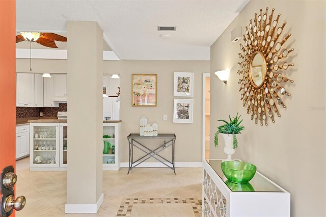 entryway with light tile patterned flooring, baseboards, and a ceiling fan