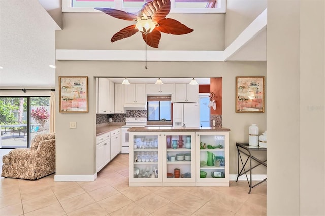 kitchen featuring white appliances, a ceiling fan, light tile patterned flooring, and healthy amount of natural light