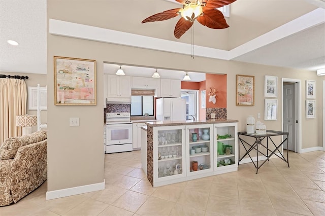 kitchen with white appliances, ceiling fan, light tile patterned floors, under cabinet range hood, and a peninsula