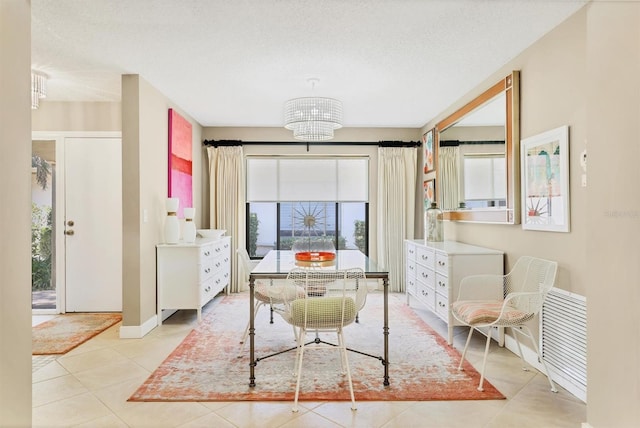 dining area featuring light tile patterned floors, a chandelier, and baseboards