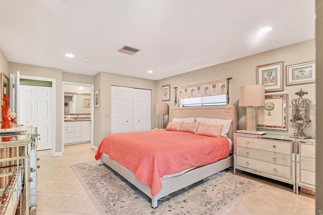 bedroom featuring light tile patterned floors, recessed lighting, ensuite bath, baseboards, and a closet