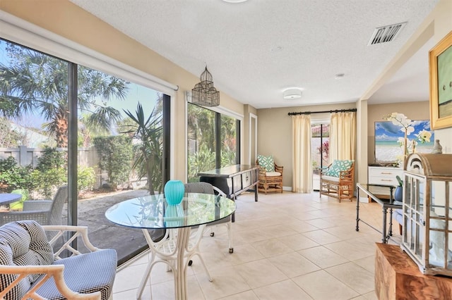 sunroom / solarium featuring a textured ceiling and tile patterned flooring