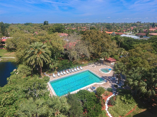 aerial view of property and surrounding area with a pool area and a large body of water
