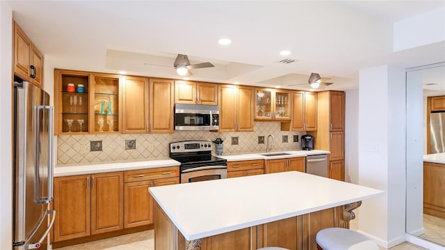 1212 Benjamin Franklin Dr Unit 909, Sarasota, FL 34236 - kitchen featuring stainless steel appliances, a sink, ceiling fan, backsplash, and recessed lighting