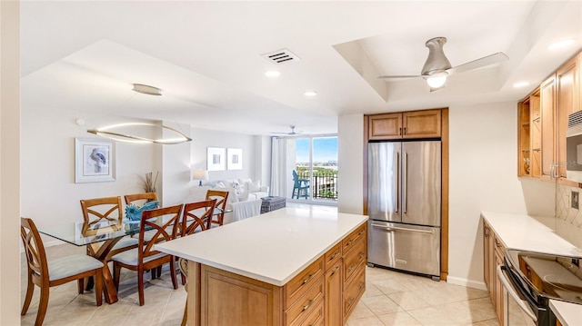 1212 Benjamin Franklin Dr Unit 909, Sarasota, FL 34236 - kitchen featuring appliances with stainless steel finishes, a ceiling fan, a raised ceiling, light countertops, and recessed lighting
