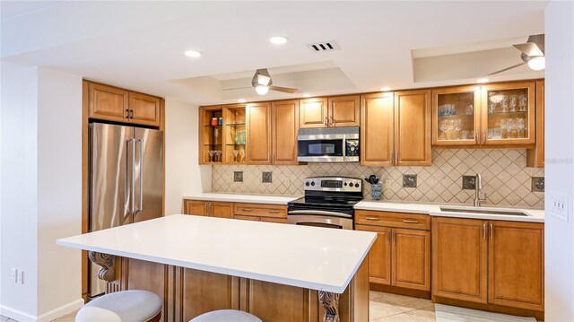 1212 Benjamin Franklin Dr Unit 909, Sarasota, FL 34236 - kitchen featuring stainless steel appliances, a tray ceiling, a sink, a kitchen breakfast bar, and open shelves