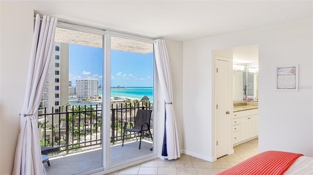 1212 Benjamin Franklin Dr Unit 909, Sarasota, FL 34236 - bedroom with access to exterior, light tile patterned floors, multiple windows, a water view, and floor to ceiling windows