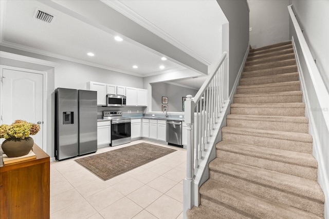 kitchen featuring appliances with stainless steel finishes, crown molding, white cabinetry, recessed lighting, and light tile patterned floors