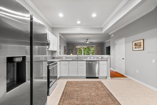 kitchen featuring stainless steel appliances, a sink, a peninsula, ornamental molding, and white cabinets