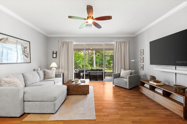 living area with ornamental molding, ceiling fan, and wood finished floors