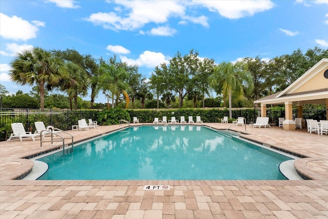 community pool featuring fence and a patio area