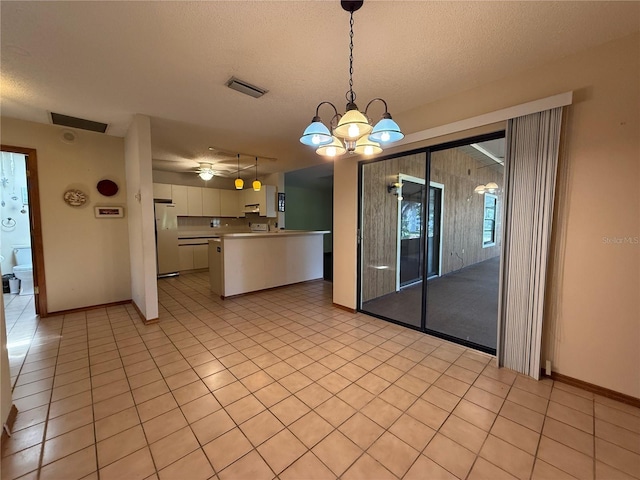 3957 Bearded Oaks Ct, Sarasota, FL 34232 - empty room featuring a textured ceiling, light tile patterned floors, a chandelier, and baseboards