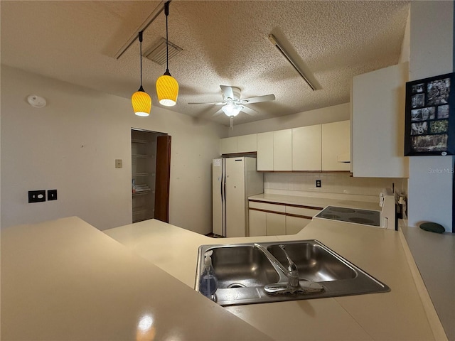 3957 Bearded Oaks Ct, Sarasota, FL 34232 - kitchen with freestanding refrigerator, stove, a ceiling fan, a textured ceiling, and decorative light fixtures