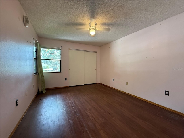 3957 Bearded Oaks Ct, Sarasota, FL 34232 - unfurnished bedroom with wood finished floors, a textured ceiling, baseboards, a closet, and a ceiling fan