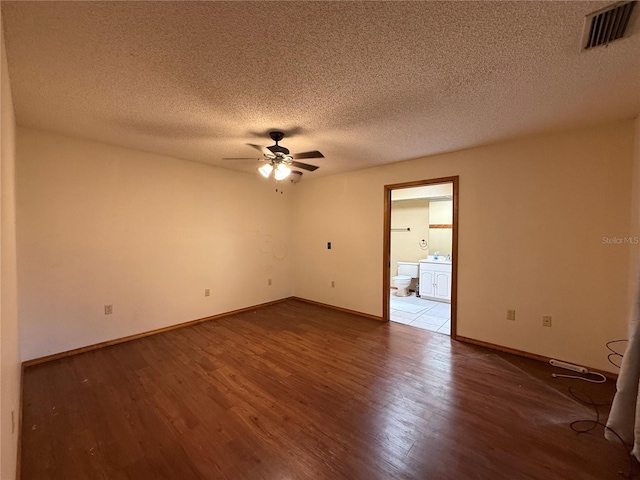 3957 Bearded Oaks Ct, Sarasota, FL 34232 - empty room with dark wood-style flooring, ceiling fan, a textured ceiling, and baseboards