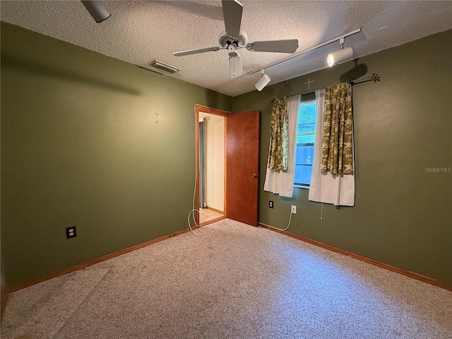 3957 Bearded Oaks Ct, Sarasota, FL 34232 - carpeted empty room with rail lighting, a textured ceiling, a ceiling fan, and baseboards