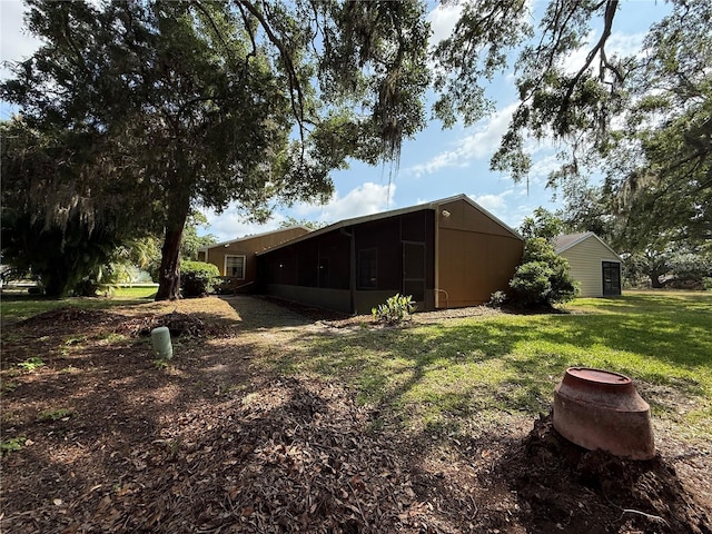 3957 Bearded Oaks Ct, Sarasota, FL 34232 - back of house with a sunroom and a lawn