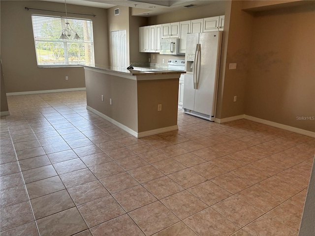 kitchen featuring white cabinets, light tile patterned floors, baseboards, and white appliances