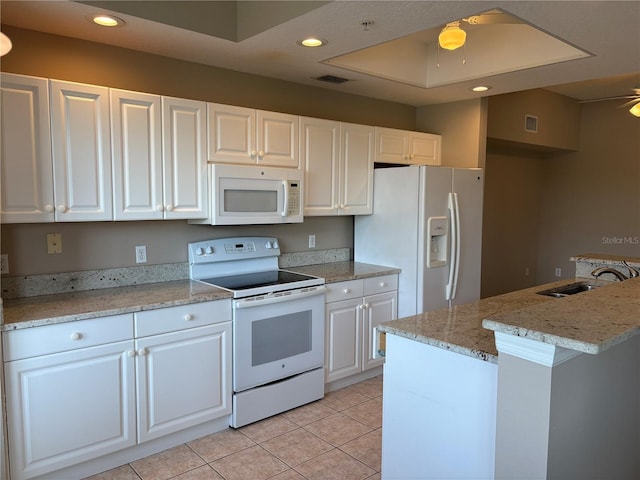 kitchen featuring a sink, white appliances, visible vents, and white cabinets