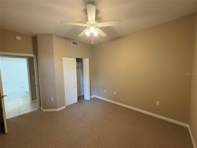 unfurnished bedroom with carpet flooring, a ceiling fan, a closet, visible vents, and baseboards